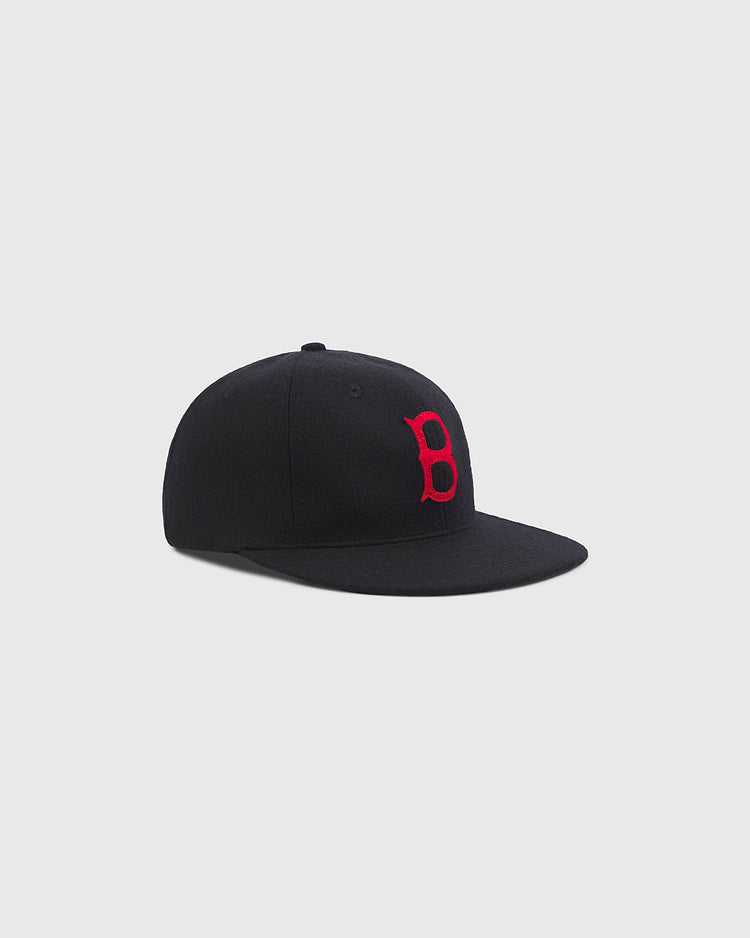A Baltimore Elite Giants 1949 Authentic Wool Ballcap by Ebbets Field, this black wool cap features a flat brim and a prominent red embroidered “B” on the front, displayed against a plain light gray background.