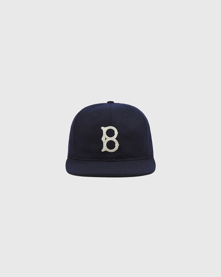 The Ebbets Field Brooklyn Royal Giants Authentic Wool Ballcap—a navy blue cap with a flat brim and a white embroidered “B” on the front—is displayed against a plain light gray background.