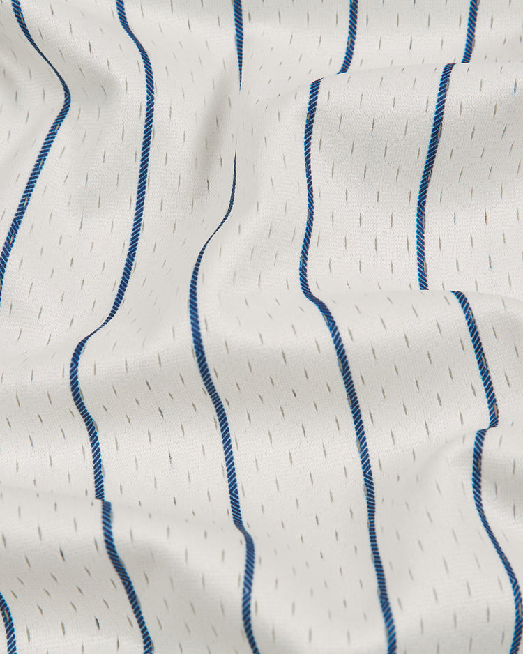White fabric featuring vertical blue stripes and subtle gray dash patterns, displayed with soft folds and wrinkles, evoking the timeless style of the Ebbets Field NY Black Yankees V-Neck Mesh Jersey.