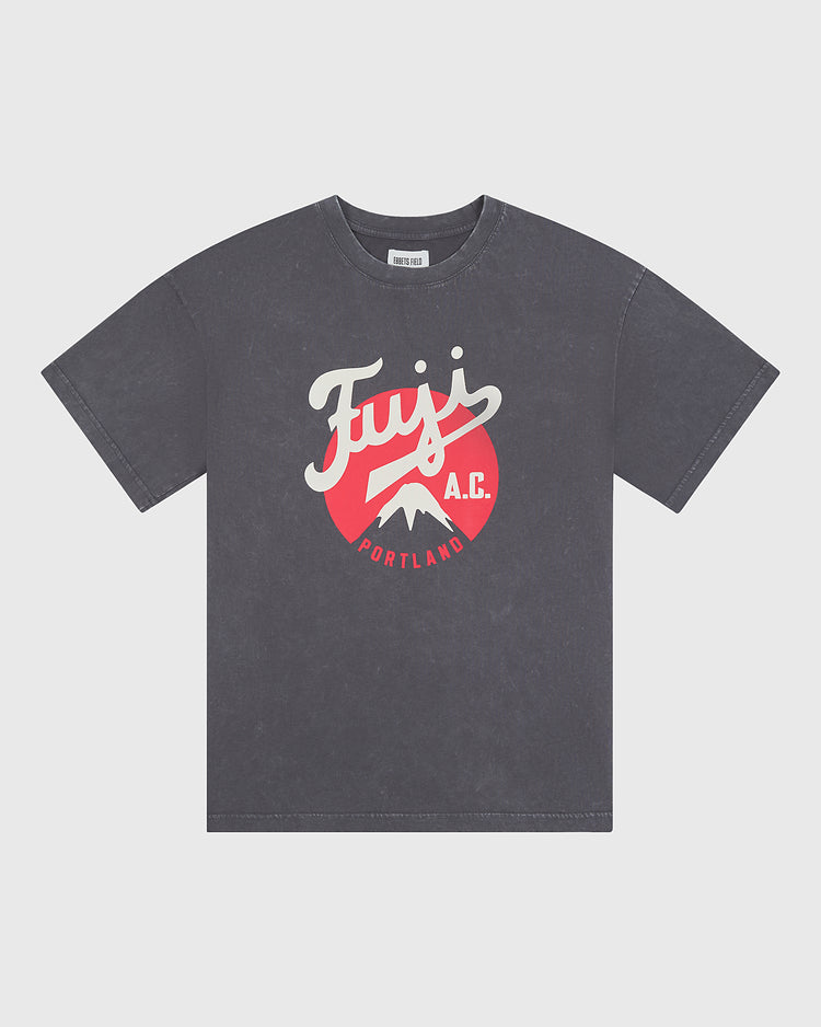 The Ebbets Field Fuji Athletic Club Pigment-Dyed Short Sleeve Graphic T-Shirt features a faded black wash and showcases a red and white front graphic with the words “Fuji A.C. Portland” alongside a mountain illustration—a tribute to Japanese American baseball history as represented by the iconic Fuji Athletic Club.