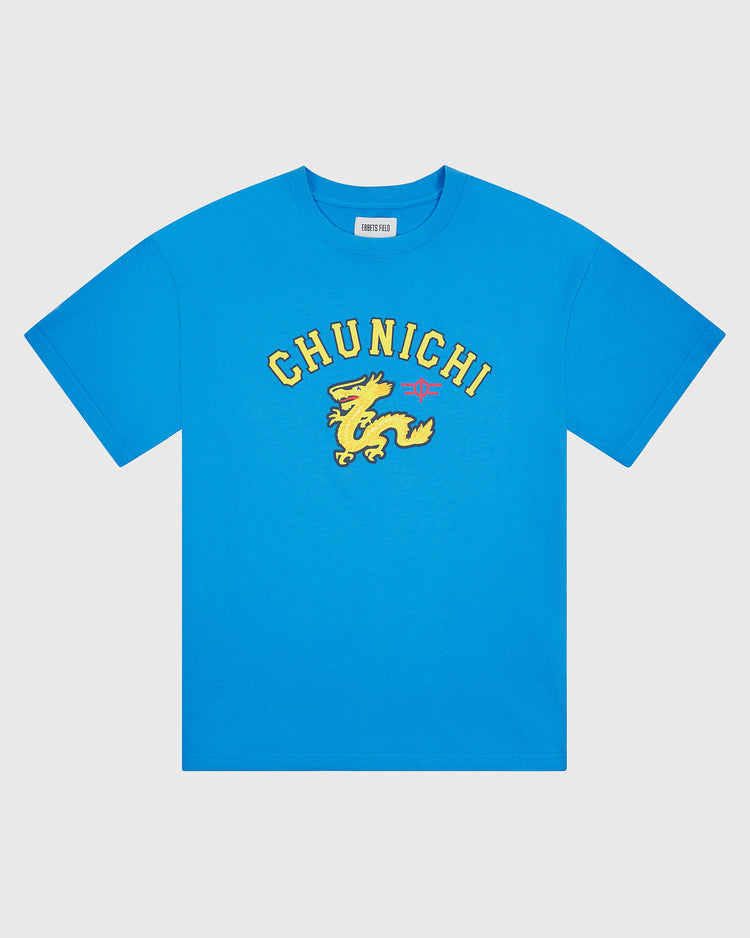The Chunichi Dragons Short Sleeve Graphic T-Shirt by Ebbets Field features a blue pigment-dyed design with “CHUNICHI” in bold yellow letters above a yellow dragon graphic and a small pink star on the chest, taking inspiration from vintage Japanese baseball shirts. The t-shirt is shown against a plain white background.