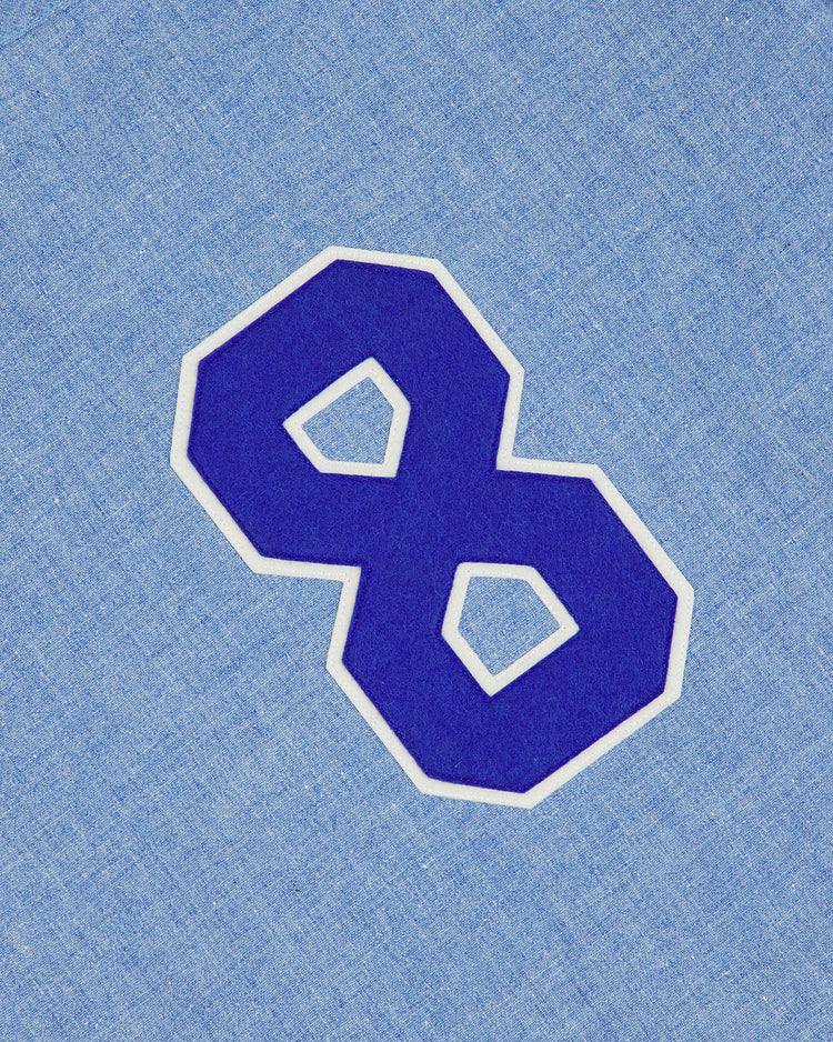 A large, bold, blue number 8 with a white outline appears on a light blue textured background, evoking the look of the Ebbets Field Chunichi Dragons 1969 Authentic Wool Road Jersey.