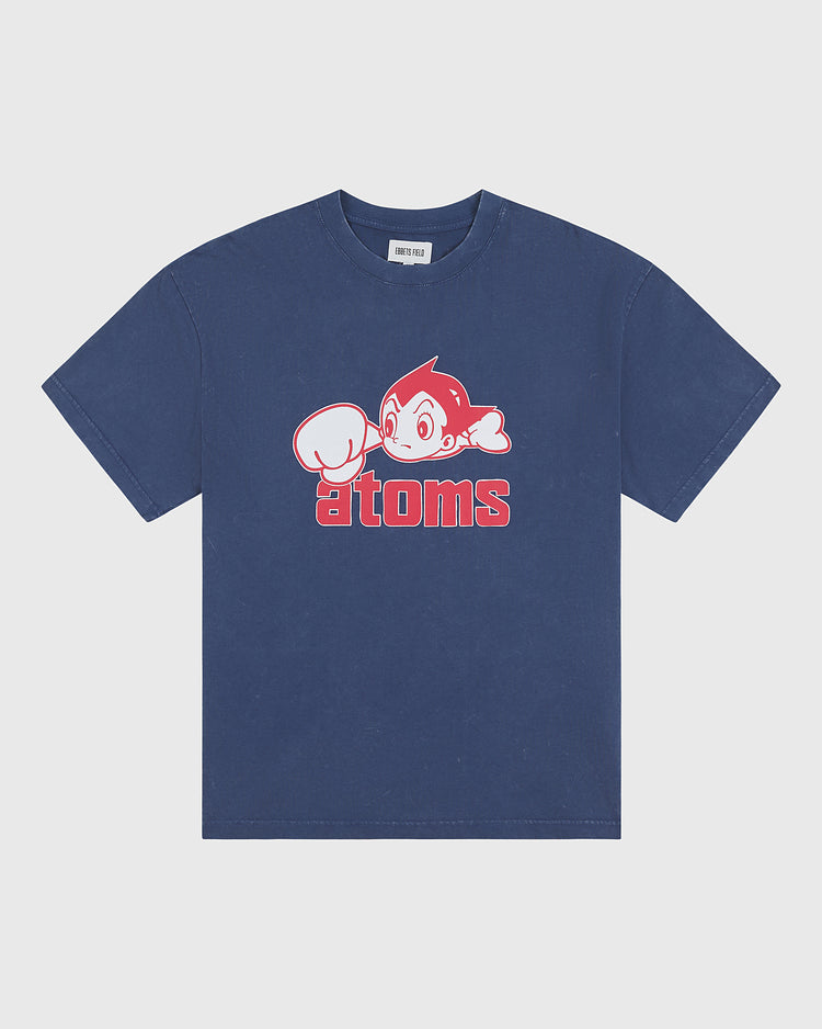 The Ebbets Field Sankei Atoms Pigment-Dyed Short Sleeve Graphic T-Shirt features a cartoon character with a raised fist above bold red “atoms” lettering, channeling vintage Tokyo baseball style and playful retro flair.
