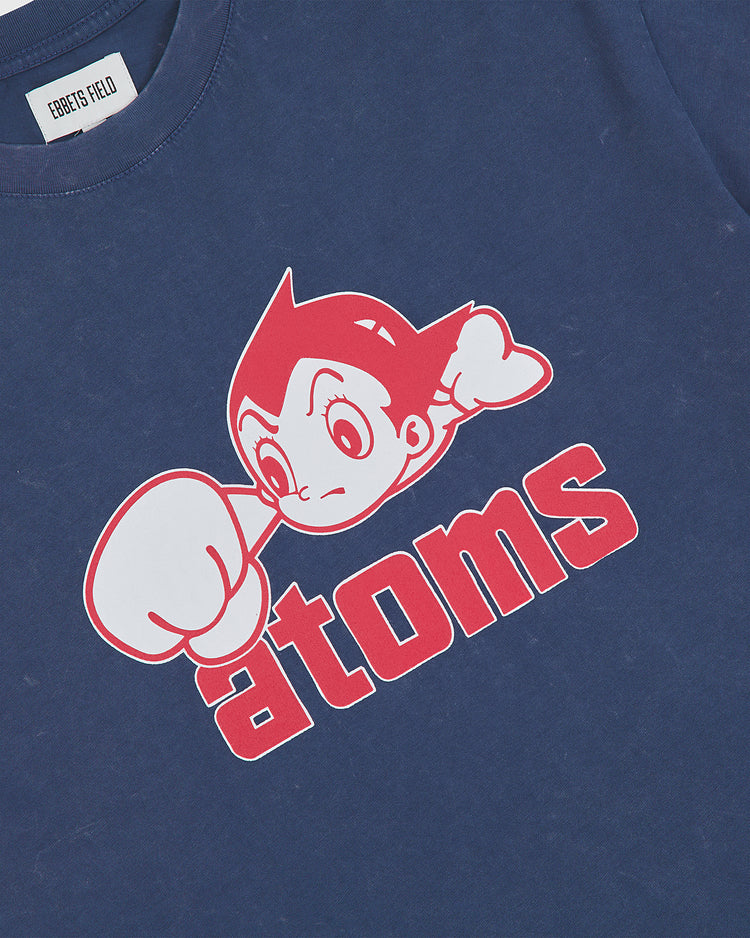The Ebbets Field Sankei Atoms Pigment-Dyed Short Sleeve Graphic T-Shirt features a retro-inspired graphic of a cartoon character with spiky hair and a large fist above bold red “atoms” lettering, capturing the vintage vibe of the classic Sankei Atoms tee.