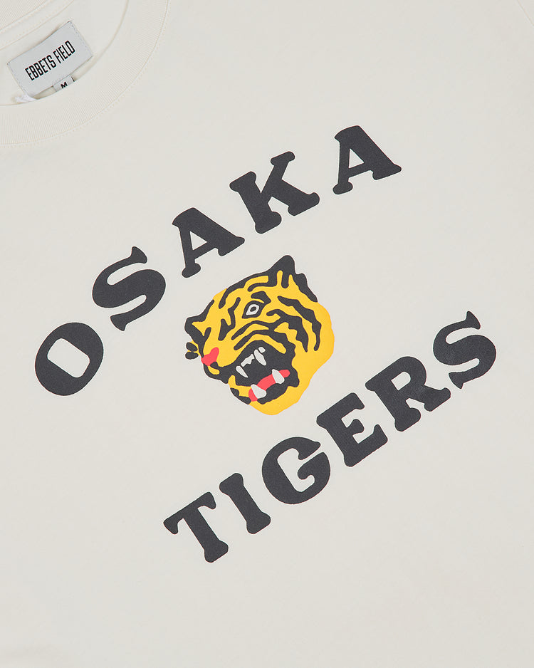 The Ebbets Field Osaka Tigers Short Sleeve Graphic T-Shirt features bold black OSAKA TIGERS lettering and a vibrant yellow roaring tiger face in the center—a perfect vintage-inspired pick for baseball fans.