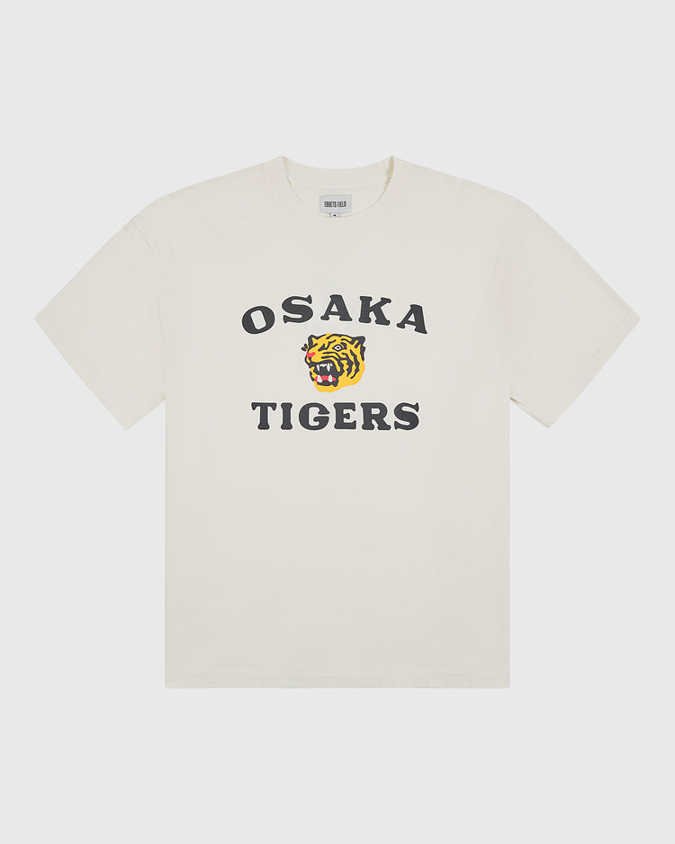 The Ebbets Field Osaka Tigers Short Sleeve Graphic T-Shirt is a white tee designed in vintage baseball style, featuring bold black “OSAKA TIGERS” lettering on the front with a roaring tiger face graphic printed between the words.