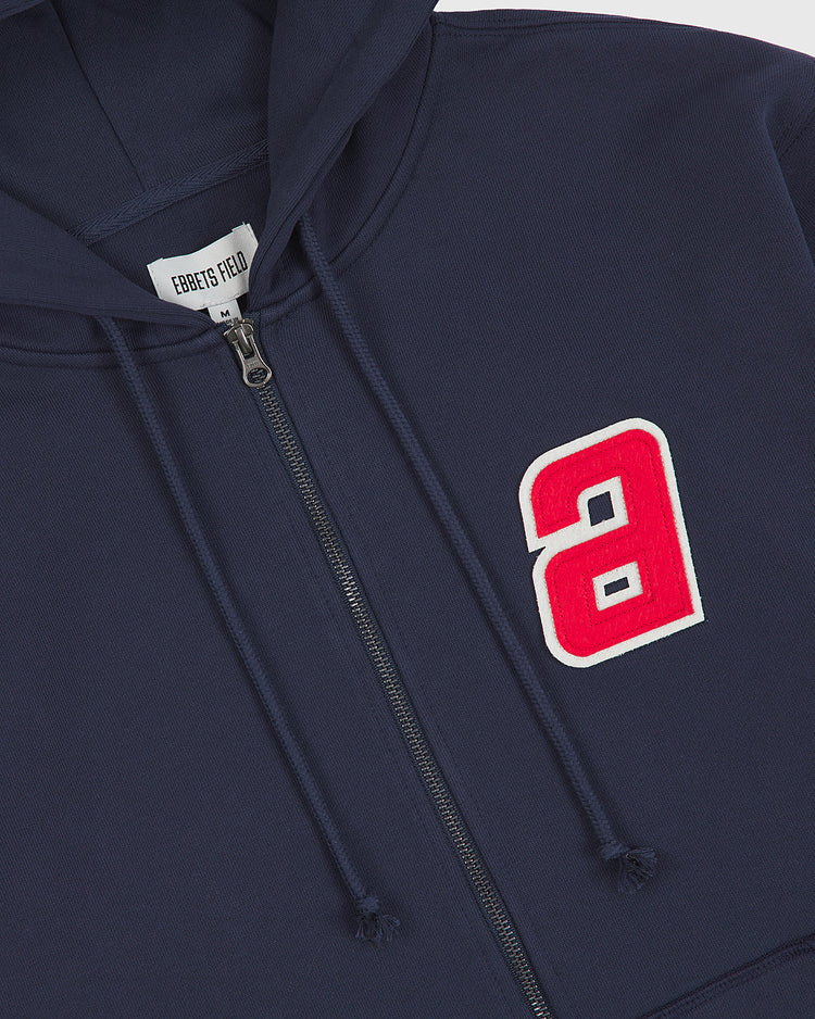 The Sankei Atoms Heavyweight Cotton Terry Full-Zip Hoodie by Ebbets Field features a navy blue design with a white and red letter “a” patch on the left chest. The label inside the collar reads Ebbets Field. This vintage-style hoodie delivers a timeless look, perfect for fans of classic athletic wear.