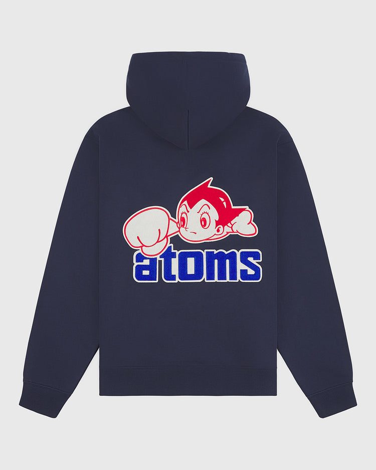 The Sankei Atoms Heavyweight Cotton Terry Full-Zip Hoodie by Ebbets Field is a navy vintage-style hoodie, featuring a graphic of a spiky-haired cartoon character with a large glove above the word “atoms” in bold blue and white lettering on the back, reminiscent of an Astro Boy sweatshirt.