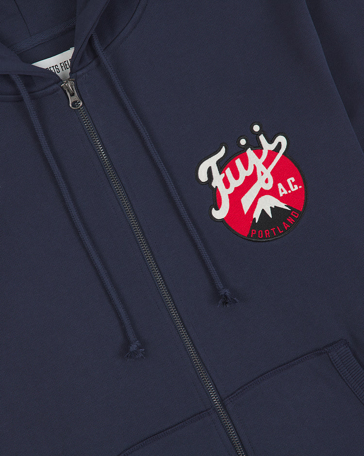 Channeling retro vibes, the Ebbets Field Fuji Athletic Club Heavyweight Cotton Terry Full-Zip Hoodie comes in classic navy blue and features a full-front zipper, adjustable drawstring hood, and an eye-catching “Fuji A.C. Portland” patch in white and red—paying homage to the legendary Japanese American baseball club. A bold mountain graphic accents the left chest for a distinctive vintage-inspired touch.