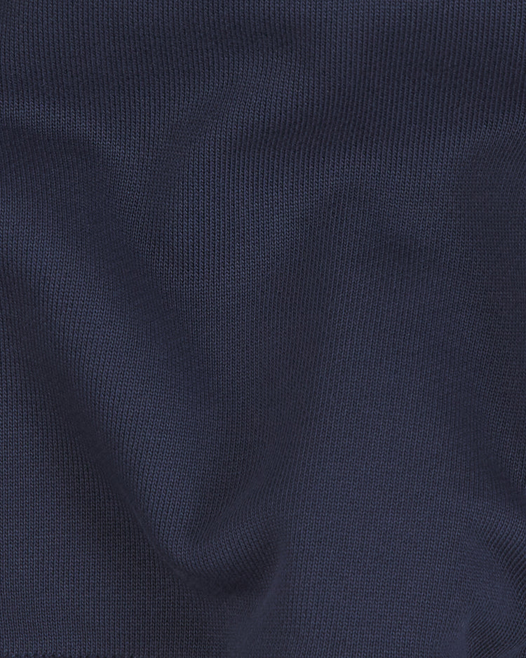 A close-up of heavyweight dark blue cotton terry fabric with visible ribbed texture and gentle folds casting subtle shadows and highlights, echoing the classic materials of vintage-style zip hoodies from Ebbets Field’s Fuji Athletic Club Heavyweight Cotton Terry Full-Zip Hoodie, inspired by Japanese American baseball heritage.