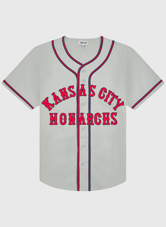 Ebbets Field Kansas City Monarchs 1936 Road Jersey Cotton Twill: light gray button-down baseball jersey with red and blue trim, featuring KANSAS CITY MONARCHS in red lettering across the chest.