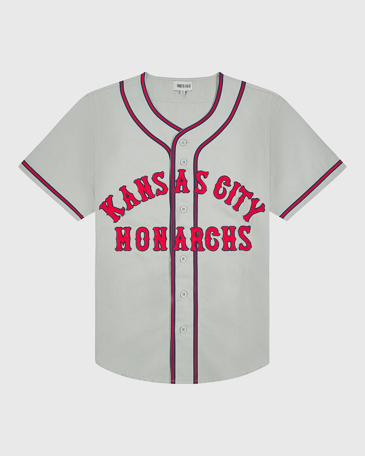 Ebbets Field Kansas City Monarchs 1936 Road Jersey Cotton Twill: light gray button-down baseball jersey with red and blue trim, featuring KANSAS CITY MONARCHS in red lettering across the chest.