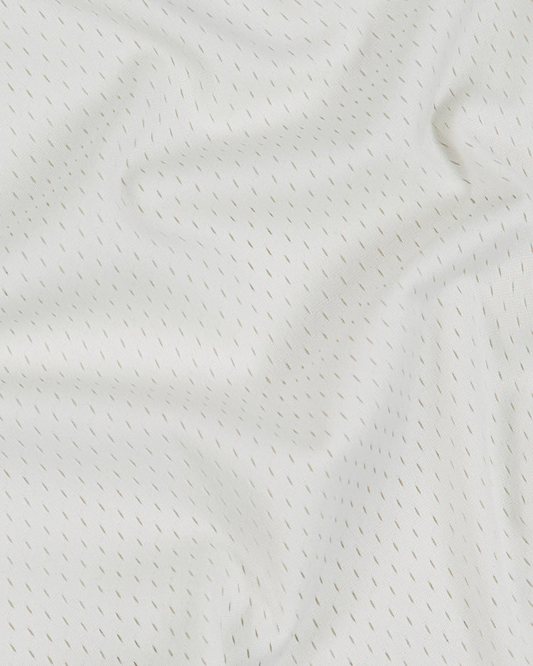 White athletic mesh fabric from an Atlanta Black Crackers 1940 V-Neck Mesh Jersey by Ebbets Field, featuring a pattern of small, repeating dark dashes.