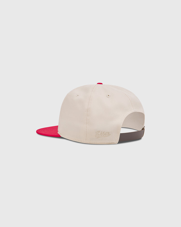 Off-white cotton twill Kansas City Monarchs 1942 Cotton Twill Ballcap by Ebbets Field with a red brim and adjustable brown leather strap.