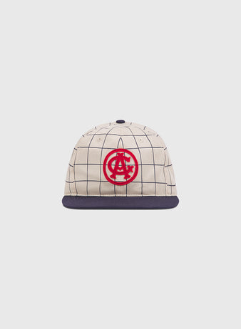 The Chicago American Giants 1919 Cotton Twill Ballcap by Ebbets Field features a beige crown, navy brim, black grid pattern, and bold red embroidered logo on the front, shown against a plain white background.