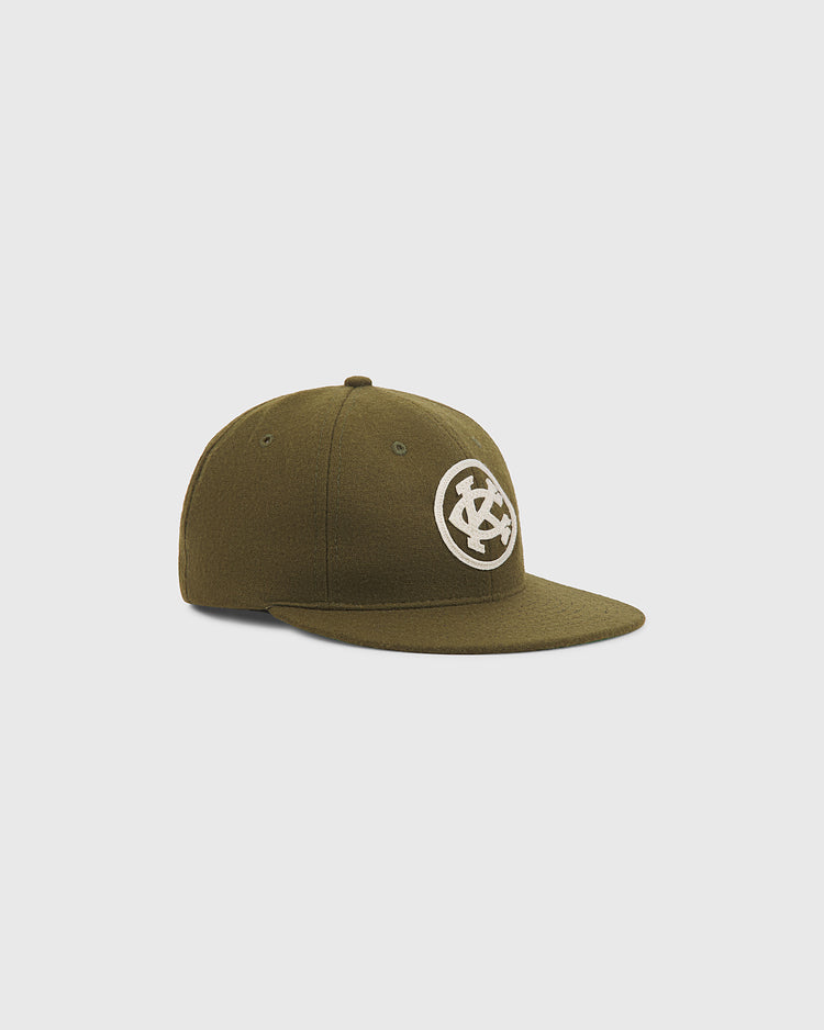 Olive green Kansas City Monarchs 1924 Authentic Wool Ballcap by Ebbets Field with a flat brim and a circular logo featuring the letters KC on the front.