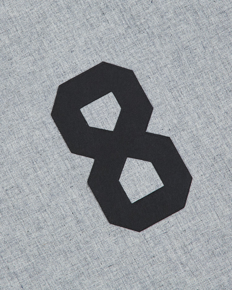 A black, blocky number 8 is centered on a light gray textured fabric background, evocative of the Ebbets Field Tokio Senators 1936 Authentic Wool Road Jersey.