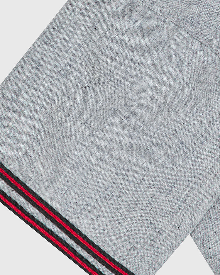 Close-up of a gray wool fabric with a visible weave pattern, featuring a hem with black, red, and green stripes near the edge—just like the Ebbets Field Tokio Senators 1936 Authentic Wool Road Jersey.