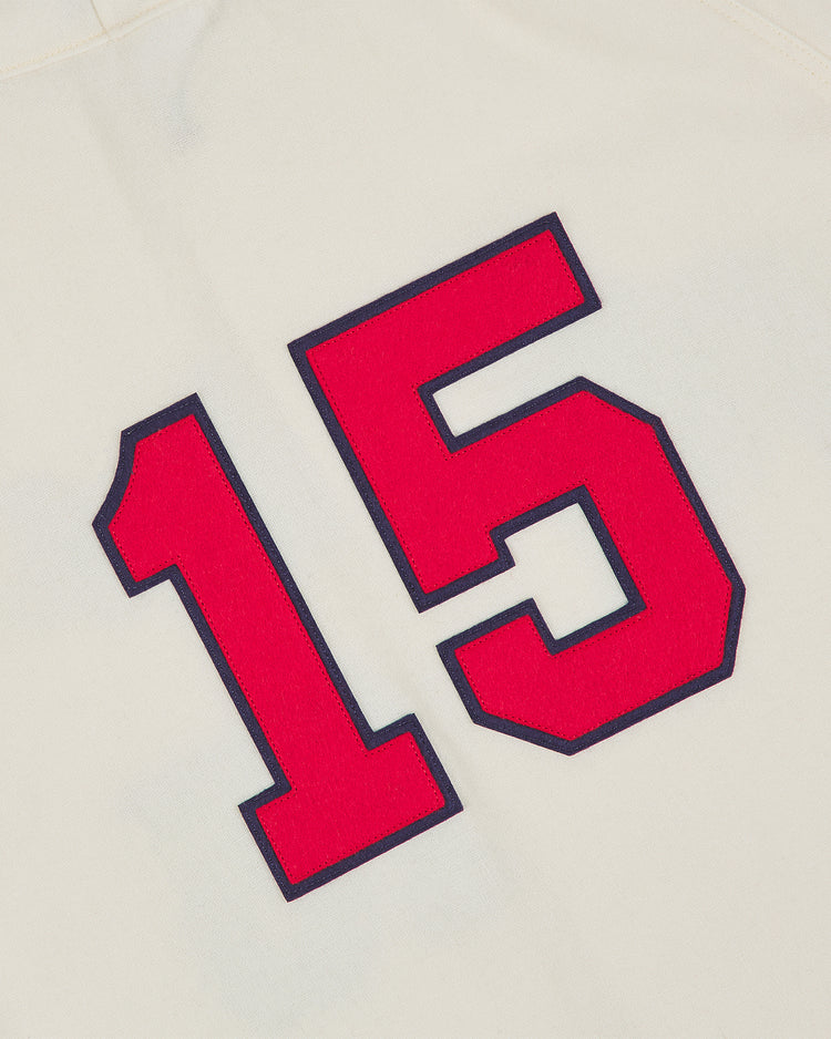 A red number 15 outlined in black on white wool fabric, as seen on the Ebbets Field Taiyo Whales 1963 Authentic Wool Home Jersey.