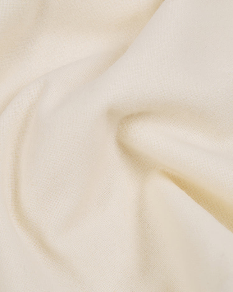 A close-up of cream-colored, soft-textured fabric reveals gentle folds and shadows, capturing the authentic wool construction and vintage style of the Ebbets Field Taiyo Whales 1963 Authentic Wool Home Jersey.