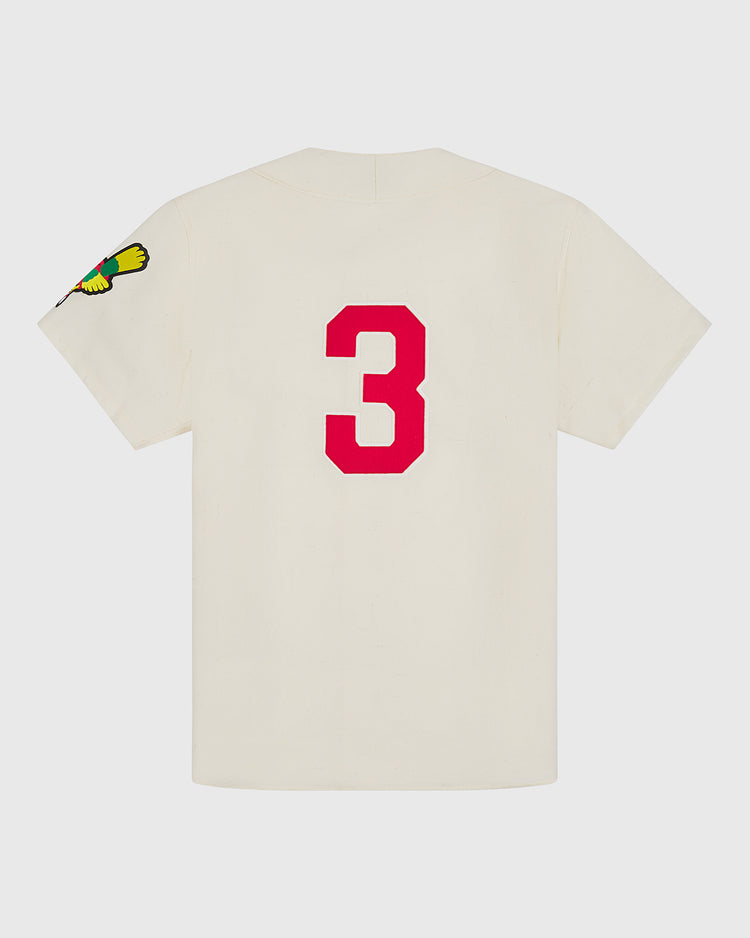 This cream-colored short sleeve shirt by Ebbets Field is inspired by the Shochiku Robins 1950 Authentic Wool Home Jersey, featuring a large red number 3 on the back and a vibrant bird patch on the left sleeve—a tribute to the classic Japanese baseball jersey.