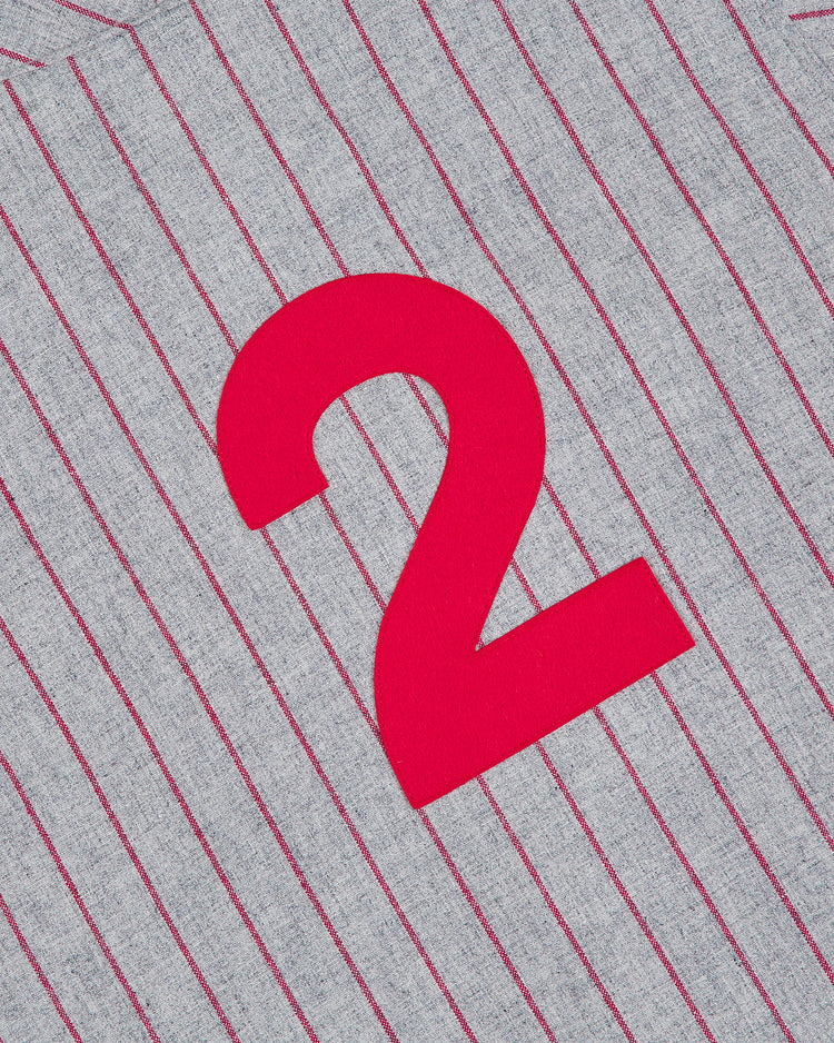A red number 2 stands out on the gray wool fabric with thin, vertical red pinstripes, capturing the vintage look of an authentic Japanese baseball jersey—specifically, the Nagoya Club 1938 Authentic Wool Road Jersey by Ebbets Field.