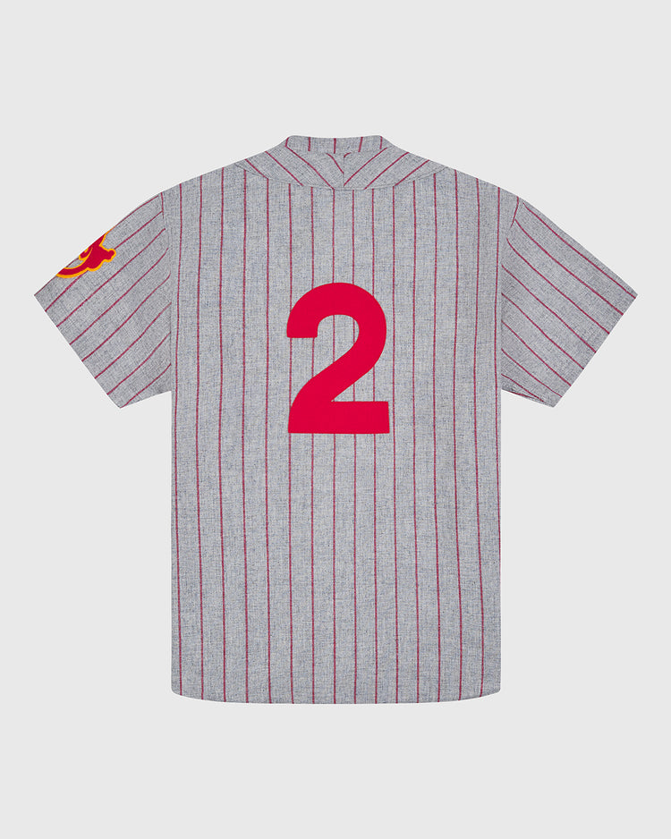 The Nagoya Club 1938 Authentic Wool Road Jersey from Ebbets Field is a gray, short-sleeve, pinstriped baseball jersey featuring red vertical stripes, a prominent red number 2 on the back, and a subtle red detail on the left sleeve. Crafted in authentic wool, this piece captures the essence of vintage Japanese baseball style.
