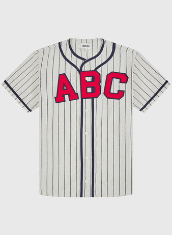 The Atlanta Black Crackers 1940 Authentic Home Jersey by Ebbets Field is a short-sleeve, white baseball jersey featuring thin black vertical stripes, a button-up front, a black-trimmed collar, and bold red “ABC” lettering across the chest.