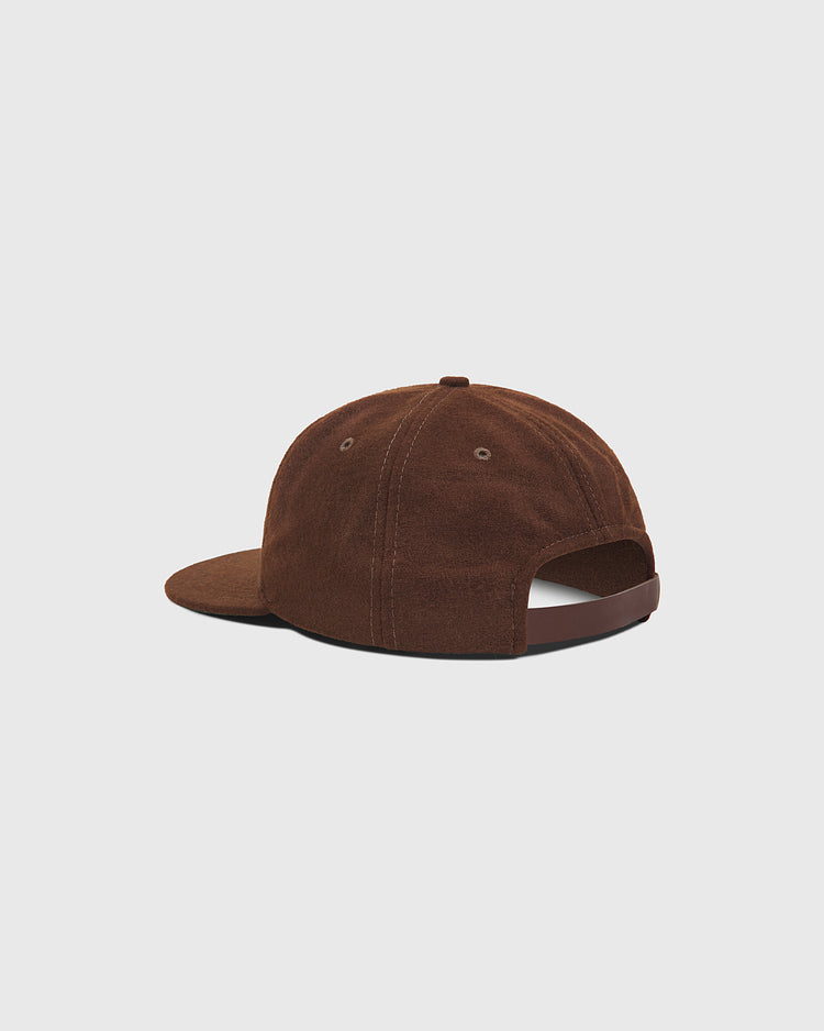 A rear view of the Salt Lake City Bees 1959 Wool Ballcap by Ebbets Field is displayed against a plain light gray background. The cap, crafted in brown suede, highlights its curved brim and adjustable back strap, evoking the classic Pacific Coast League look worn by teams like the 1959 Salt Lake City Bees.
