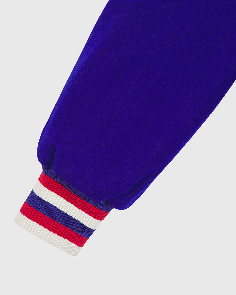 A close-up of a royal blue sleeve with a ribbed cuff featuring red, white, and blue horizontal stripes, from the EFF Chicago Cubs 1954 Authentic All Wool Varsity Jacket inspired by the classic 1950s replica style.