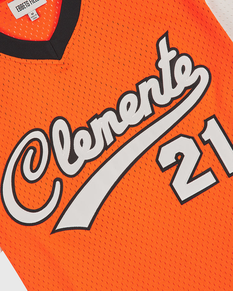 The Clemente Museum x Ebbets Field V-Neck Mesh Jersey by Ebbets Field features vibrant orange mesh fabric with black trim, “Clemente” displayed in bold white script across the chest, and number 21 in striking white numerals outlined in black. Expertly crafted from breathable mesh jersey material, this jersey boasts durable tackle twill appliqué for an authentic look and feel.