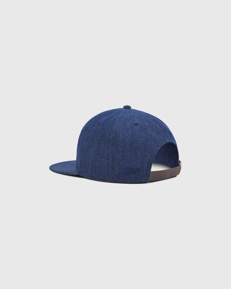 The Ebbets Field Hiroshima Carp Indigo Cotton Denim Twill Ballcap, inspired by Japanese baseball, is presented from the back angle to showcase its adjustable strap and curved brim, set against a plain light grey background.