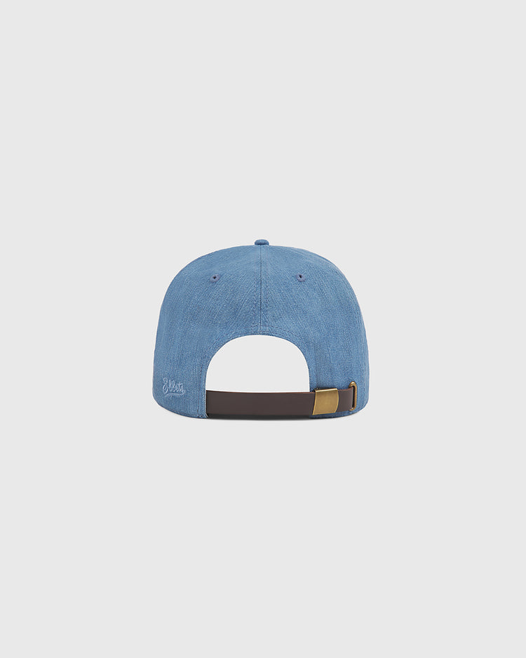 The Los Angeles (PCL) Indigo Cotton Denim Ballcap by Ebbets Field is shown from the back, highlighting its adjustable brown strap with a gold buckle. This light blue denim cap features visible stitching and a small embroidered logo on the lower left side, offering a subtle nod to classic PCL history.