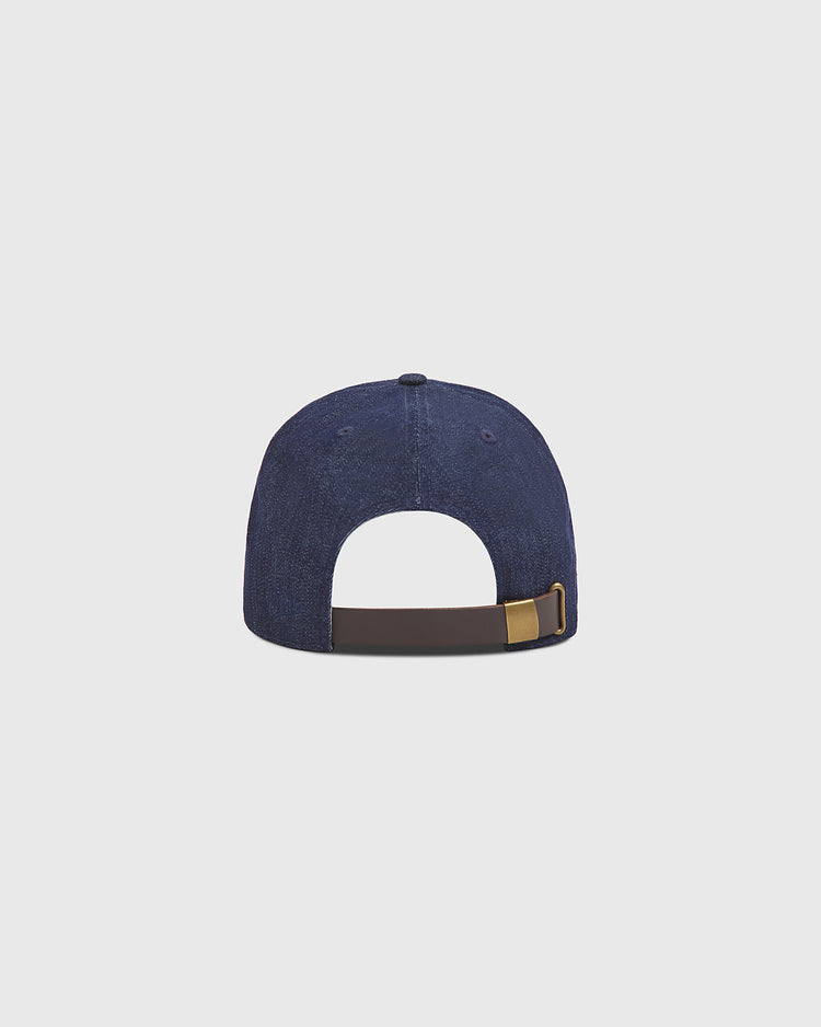 Back view of the Ebbets Field Brooklyn Bushwicks Indigo Cotton Denim Ballcap, featuring a brown adjustable strap and brass buckle, displayed against a plain light gray background.