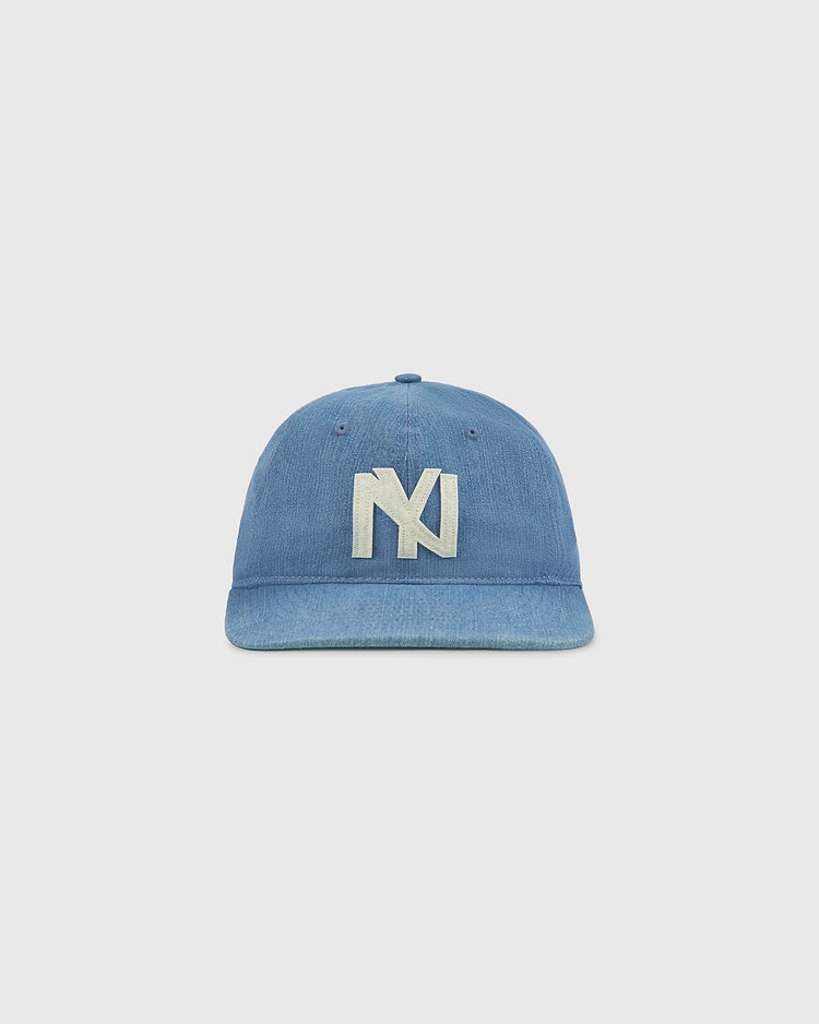 An indigo cotton denim ballcap by Ebbets Field, featuring a large white embroidered overlapping 'N' and 'Y' logo on the front in the classic style of the New York Brooklyn Eagles, displayed against a plain light background.