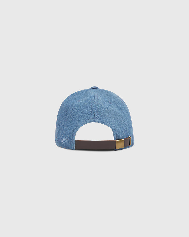 An indigo cotton denim ballcap from Ebbets Field, the New York Brooklyn Eagles model, is shown from the back with an adjustable brown strap and metal clasp, set against a plain light gray background.