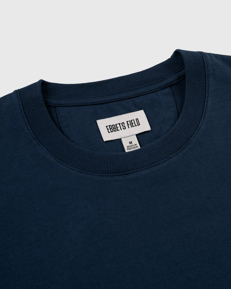 A close-up of the collar and label of a navy blue New York Black Yankees Embroidered NY Short Sleeve Tee by Ebbets Field, featuring a medium size tag and inspired by the legacy of the Negro National League.