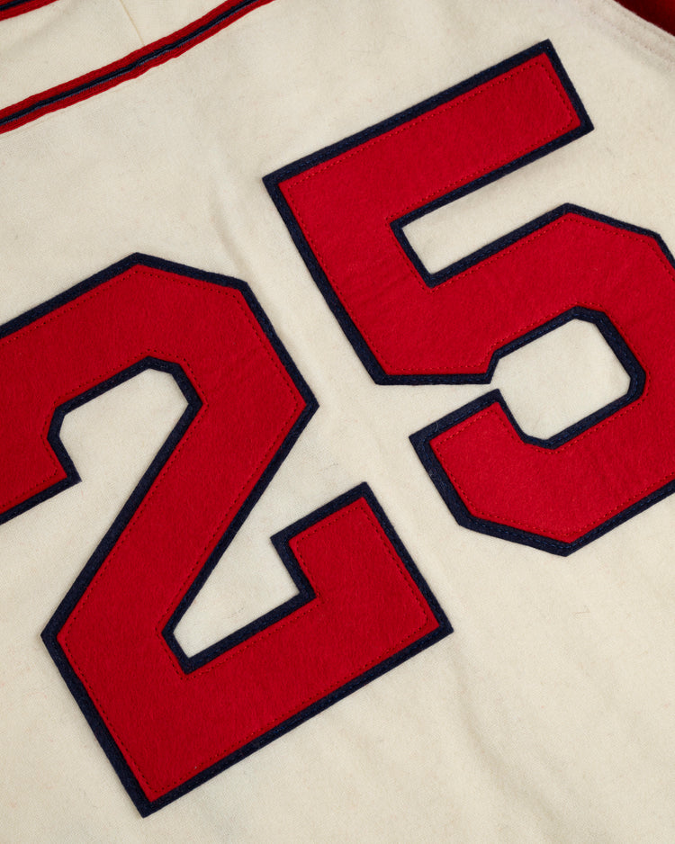 Close-up of the Ebbets Field Kansas City Monarchs 1942 Authentic Wool Home Baseball Jersey, showing a large red 25 outlined in black on white fabric with thin red seam lines, reminiscent of Satchel Paige’s classic uniform.