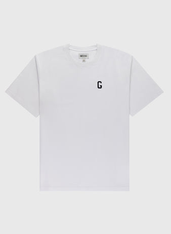 The Ebbets Field Flannels Homestead Grays Embroidered G Short Sleeve Tee is a white shirt featuring a small black ‘G’ honoring Josh Gibson on the left chest, shown against a light gray background.