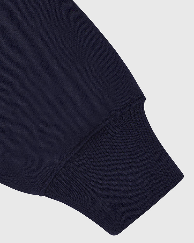 Close-up of the ribbed knit cuff on the Ebbets Field UCONN HOODIE NAVY, highlighting detailed stitching and fabric texture against a light gray background.