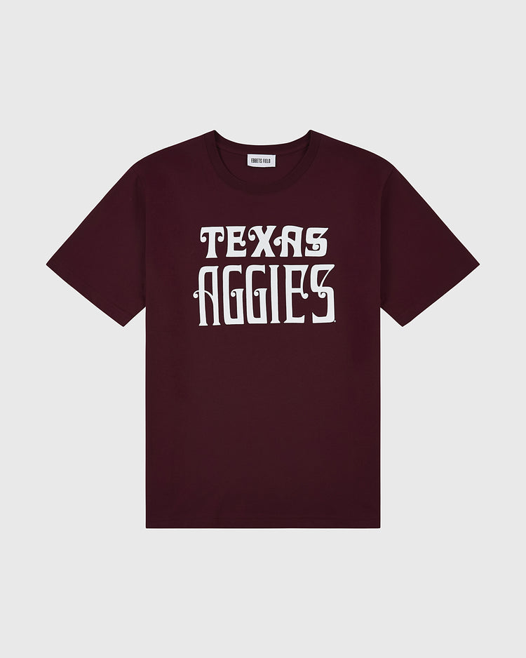 The Ebbets Field TEXAS A&M SS TEE MAROON features bold white TEXAS AGGIES text in a stylized font on the front and is displayed flat on a light gray background.