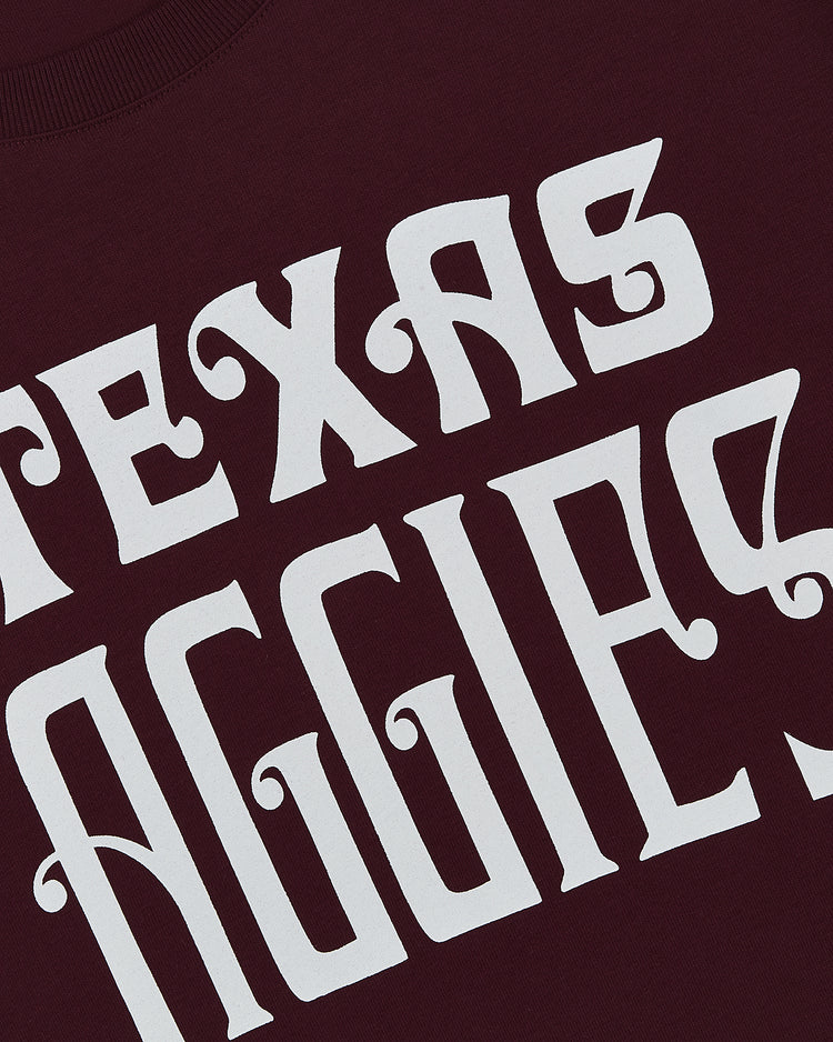 Close-up of the Ebbets Field TEXAS A&M SS TEE MAROON featuring bold white TEXAS AGGIES text in a decorative font.