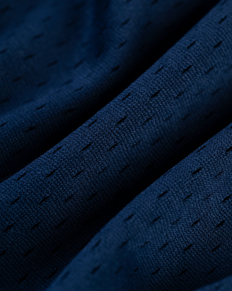 Close-up of the Ebbets Field AARON JUDGE BUTTON UP MESH JERSEY in Navy, showing its dark blue perforated mesh fabric with gentle folds for a soft, rippled look.
