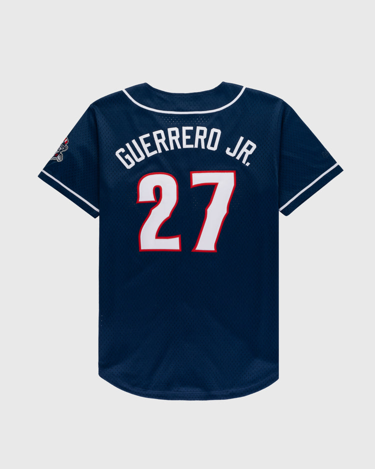 The Ebbets Field VLAD GUERRERO JR BUTTON UP MESH JERSEY in navy features white trim, GUERRERO JR. and number 27 in bold white and red on the back, plus a patch on the left sleeve.