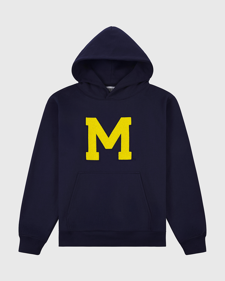 The Ebbets Field University of Michigan Heavyweight Cotton Terry Pullover Hoodie features a vintage navy design, bold yellow M on the front, and a kangaroo pocket. Displayed on a plain light background.