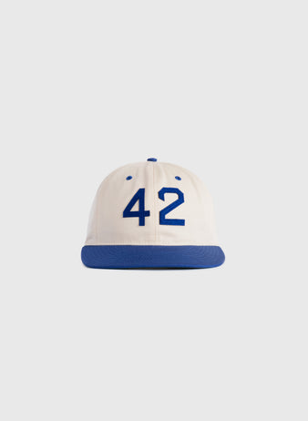 The Ebbets Field Jackie Robinson Day ‘42’ Cotton Twill Ballcap features a white crown, blue brim, and bold blue 42 on the front, honoring baseballs legacy—displayed against a plain light background.