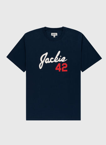 The Jackie Robinson Script 42 Short Sleeve Tee by Ebbets Field features navy blue fabric, Jackie in white script, and a red 42 on the front—a tribute to the Brooklyn Dodgers legend. Includes a crew neck and short sleeves.