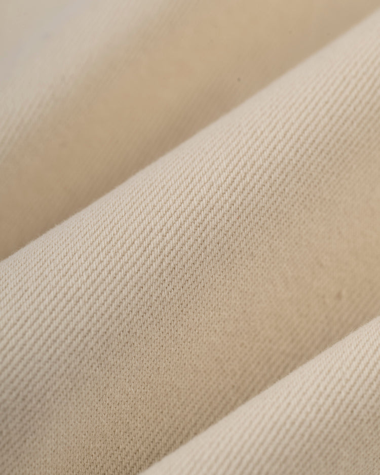 Close-up of Ebbets Fields Hawaii Islanders (PCL) Cotton Twill Baseball Jersey, showcasing its beige color and subtle diagonal weave, highlighting the vintage-inspired texture and fine threads in soft natural light.