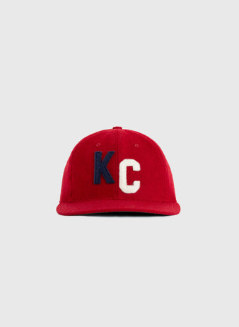 The EFF Kansas City Monarchs 1936 Authentic Wool Ballcap features a red design with bold blue K and white C embroidery, inspired by the original 1936 team cap, shown against a plain gray background.