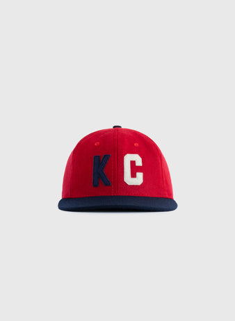 The Kansas City Monarchs 1954 Authentic Wool Ballcap by EFF features a red crown, navy blue brim, and large KC letters—K in navy, C in white—evoking classic Negro Leagues style against a plain light gray background.